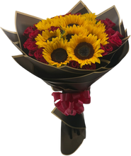 Load image into Gallery viewer, Bouquet Maravilloso con girasoles y rosas rojas en envoltura negra con bordes dorados.